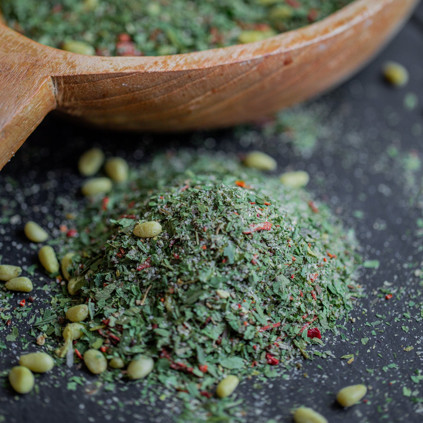 Bärlauch-Pesto mit Holzlöffel auf dunklem Untergrund