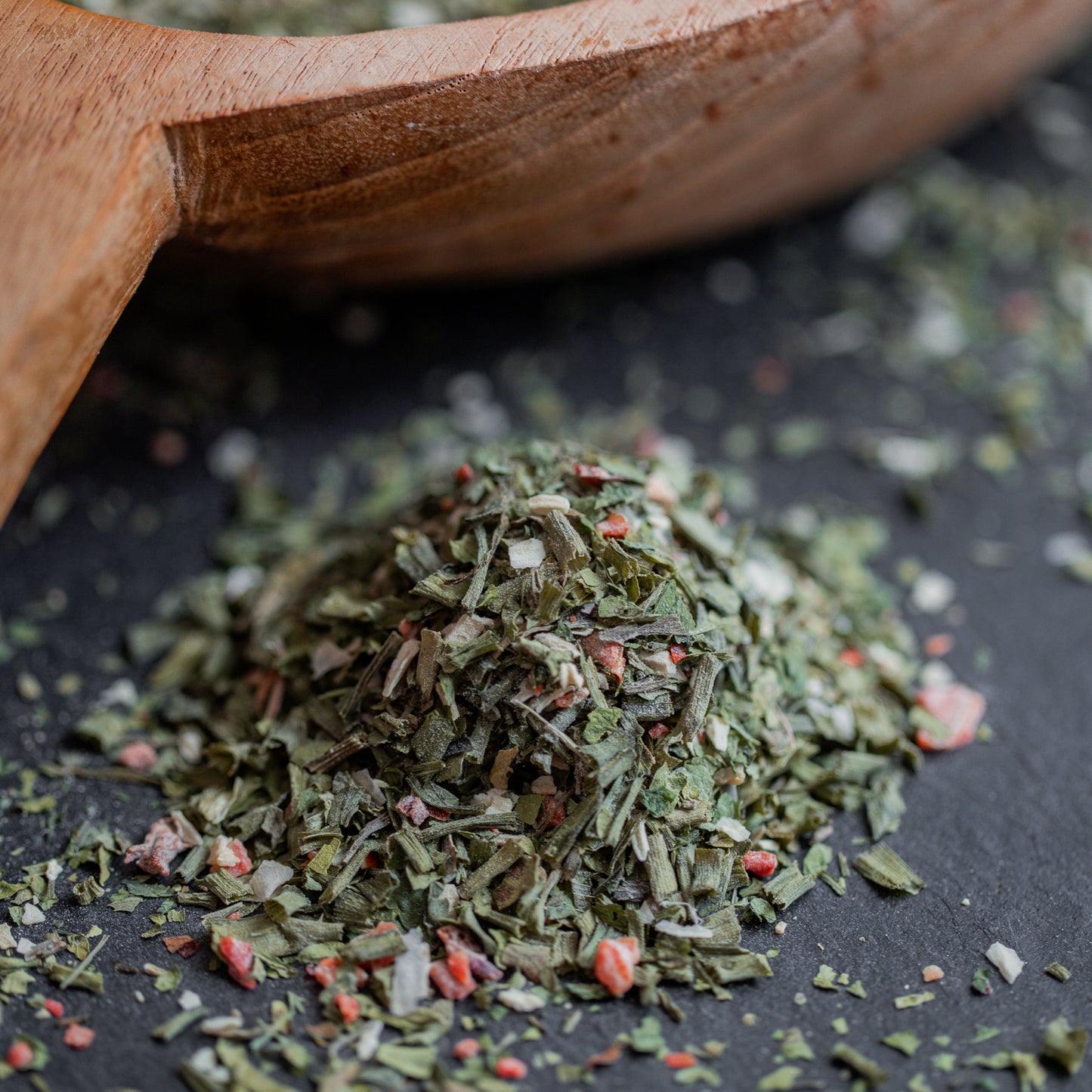 Salatkräuter grob auf dunklem Untergrund mit Holzlöffel