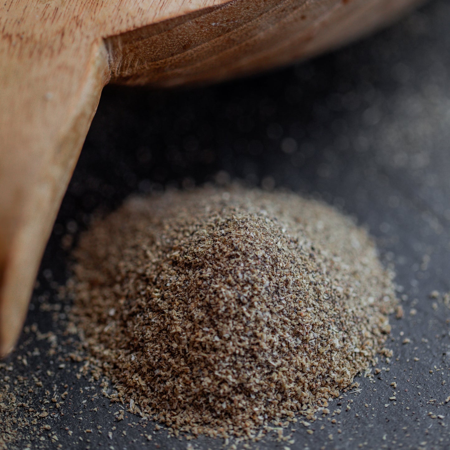 Zwiebelpfeffer fein auf dunklem Untergrund mit Holzlöffel