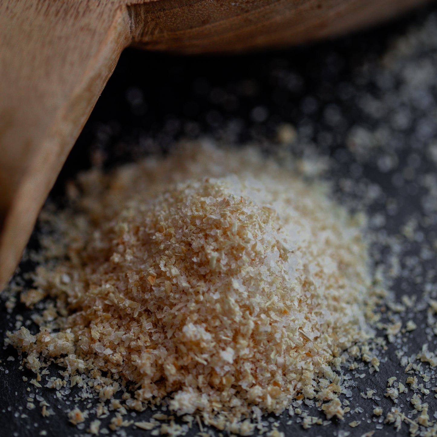 Zwiebelsalz auf dunklem Untergrund mit Holzlöffel