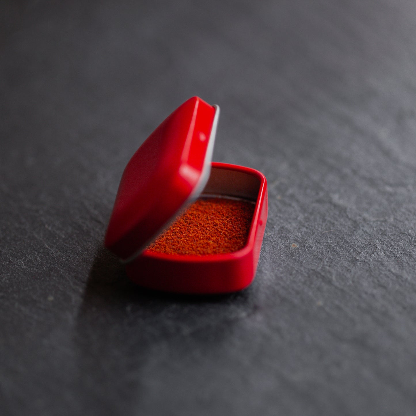 Safran gemahlen in roter Metalldose auf dunklem Untergrund