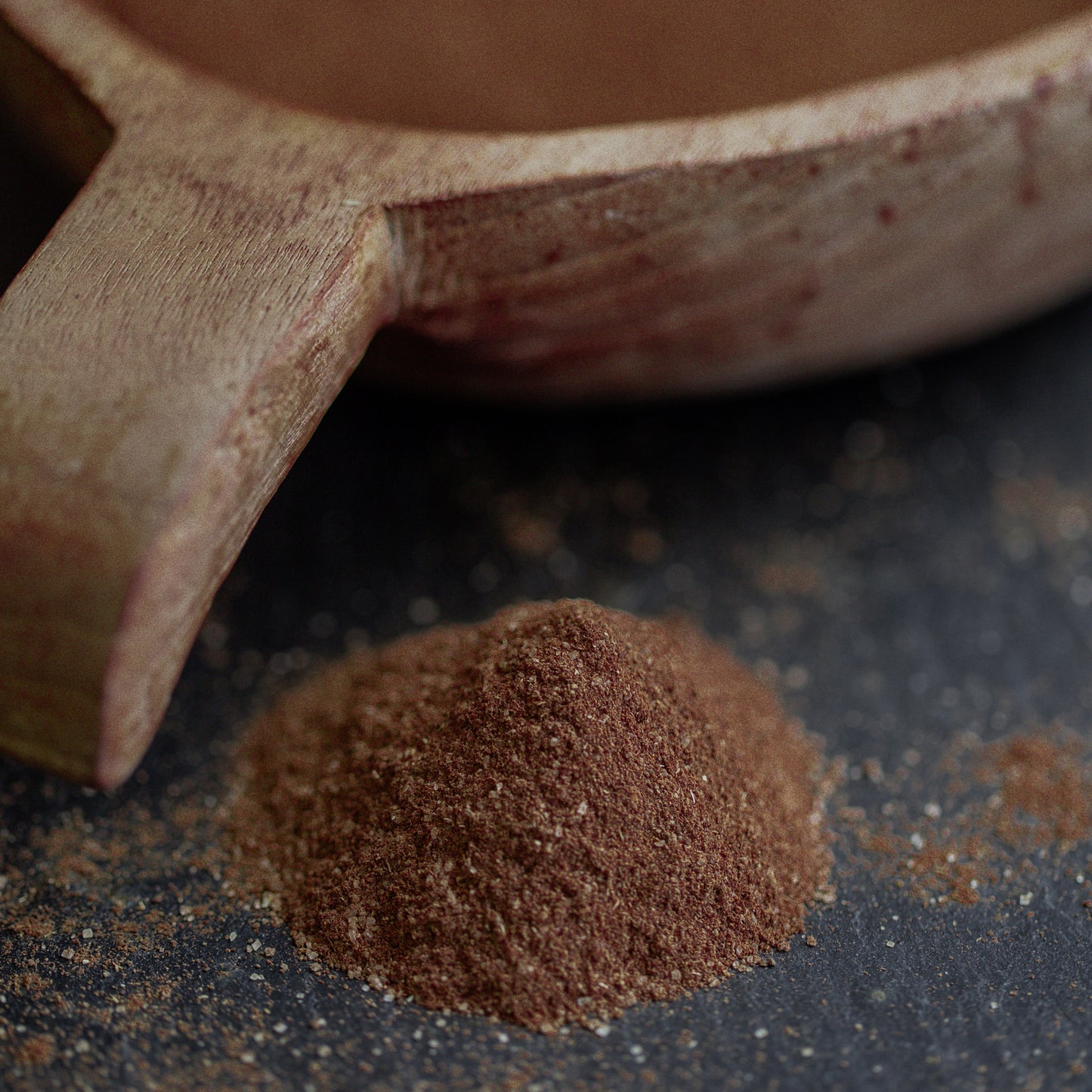 Vanille gemahlen auf dunklem Untergrund mit Holzlöffel