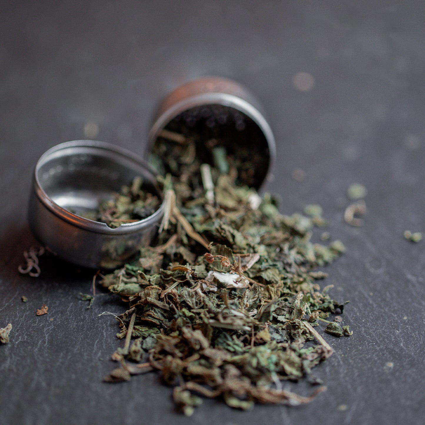 BrennnesselTee im Metalsieb auf dunklem Untergrund