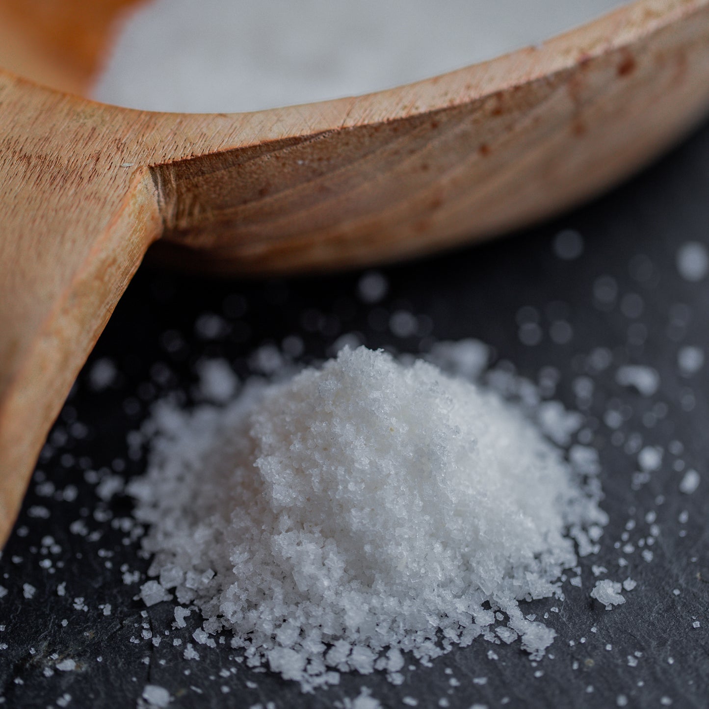 Fleur de Sel auf dunklem Untergrund mit Holzlöffel