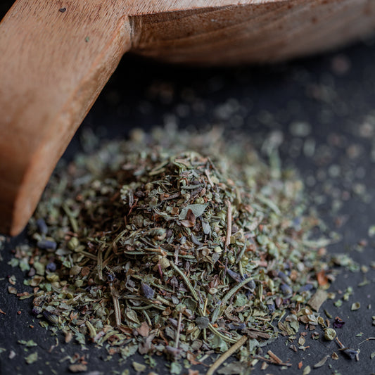 Herbes de Provence auf dunklem Untergrund mit Holzlöffel