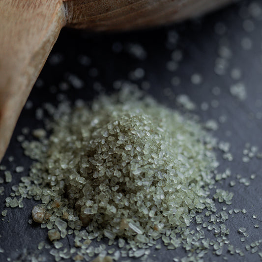 Meersalz grün, grob auf dunklem Untergrund mit Holzlöffel